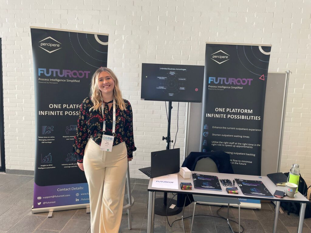 FutuRoot booth at ICPM 2024, showcasing innovative process mining solutions with AI integration, featuring interactive displays and engaging representative at the International Conference on Process Mining.